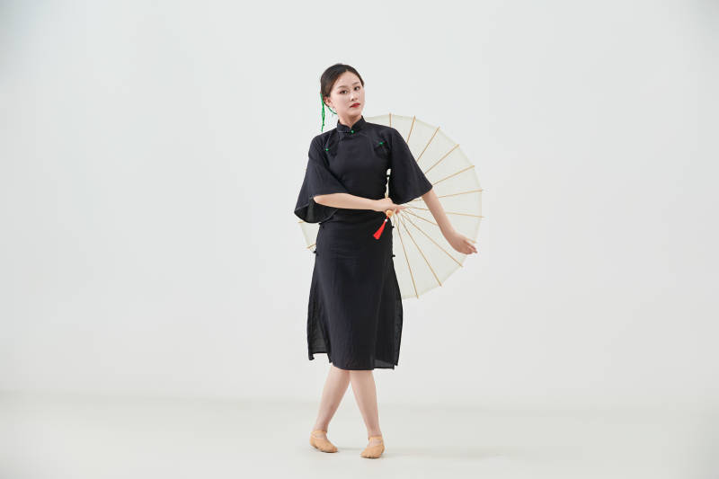 穿中式旗袍手拿油纸伞翩翩舞蹈的亚洲少女舞者图片