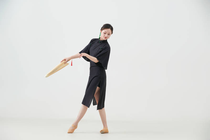 穿中式旗袍手拿油纸伞翩翩舞蹈的亚洲少女舞者图片