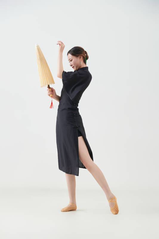 穿中式旗袍手拿油纸伞翩翩舞蹈的亚洲少女舞者图片