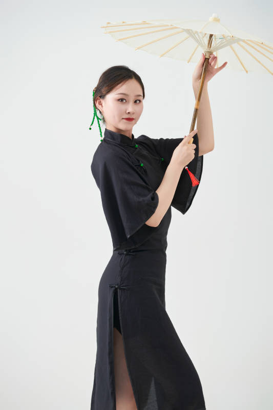 穿中式旗袍手拿油纸伞翩翩舞蹈的亚洲少女舞者图片