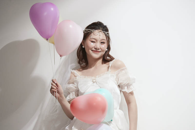 穿着公主裙手拿气球庆祝生日的亚洲女性图片