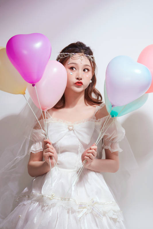 穿着公主裙手拿气球庆祝生日的亚洲女性图片