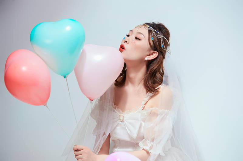 穿着公主裙手拿气球庆祝生日的亚洲女性图片