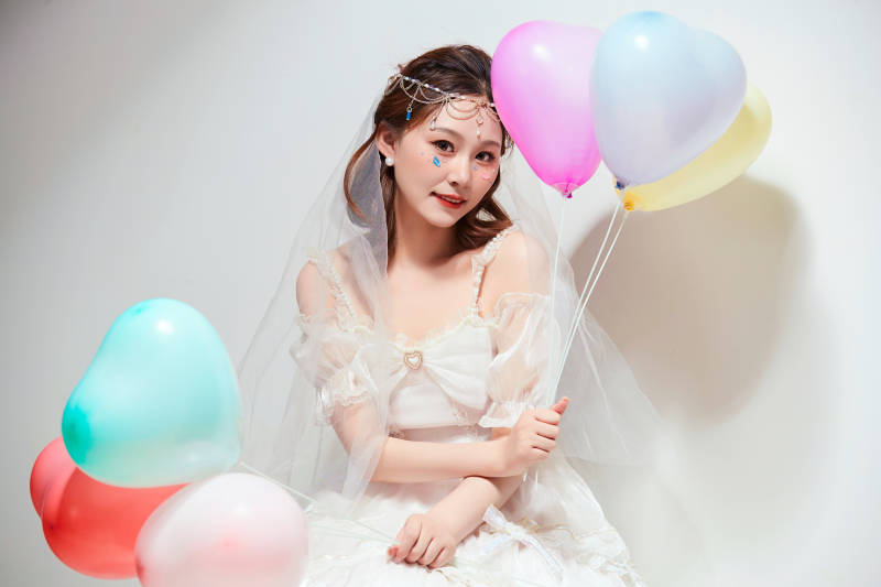 穿着公主裙手拿气球庆祝生日的亚洲女性图片