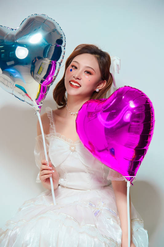 穿着公主裙手拿气球庆祝生日的亚洲女性图片