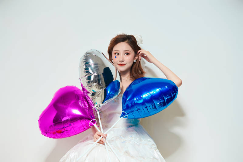 穿着公主裙手拿气球庆祝生日的亚洲女性图片