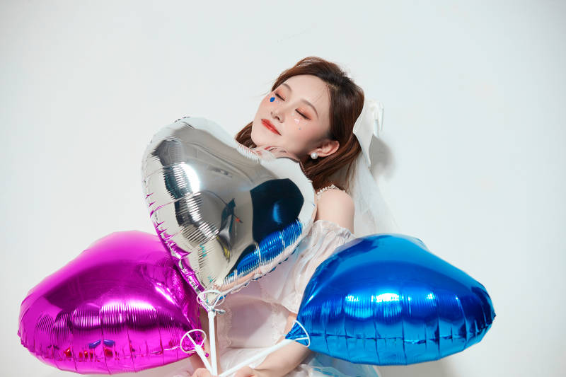 穿着公主裙手拿气球庆祝生日的亚洲女性图片