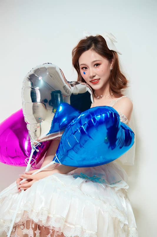 穿着公主裙手拿气球庆祝生日的亚洲女性图片
