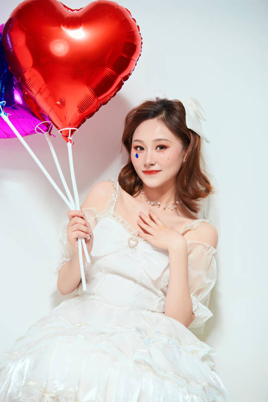 穿着公主裙手拿气球庆祝生日的亚洲女性图片