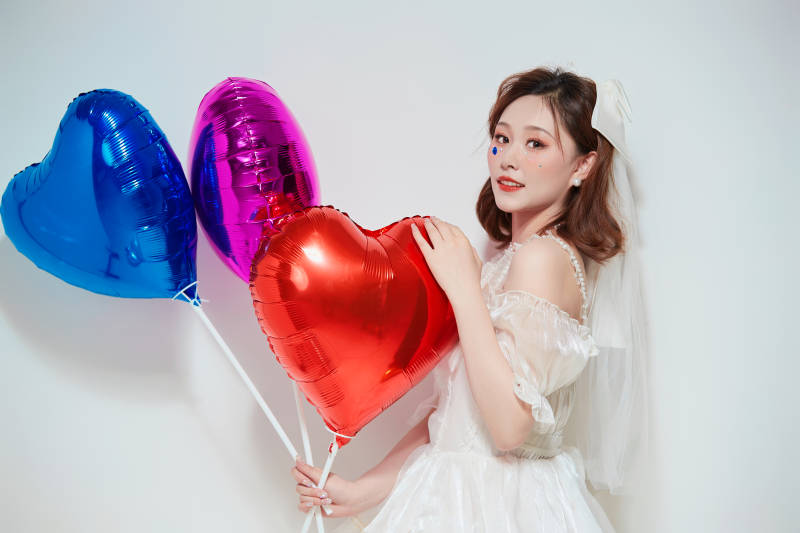 穿着公主裙手拿气球庆祝生日的亚洲女性图片