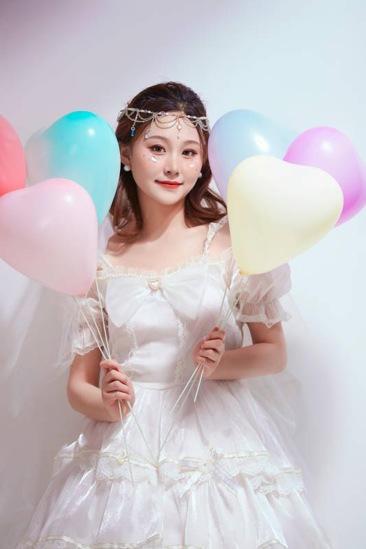 穿着公主裙手拿气球庆祝生日的亚洲女性图片