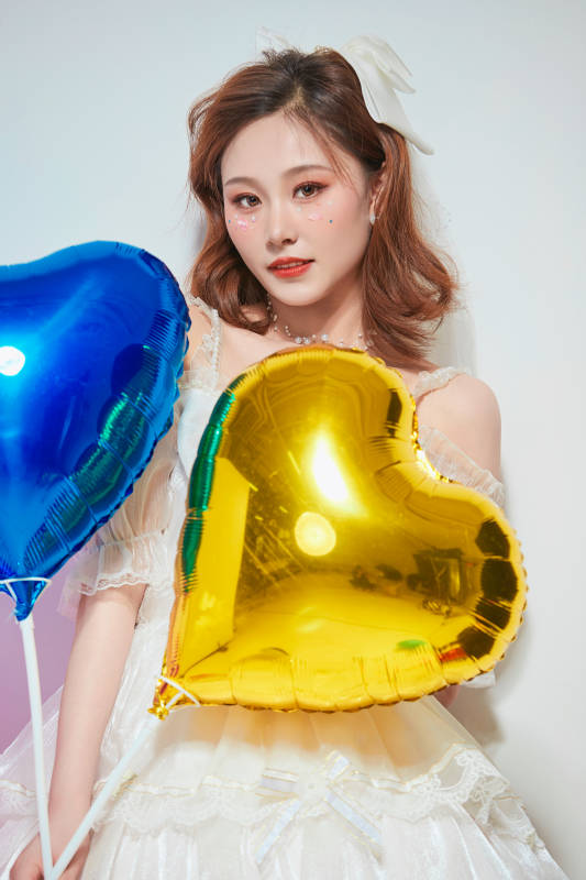 穿着公主裙手拿气球庆祝生日的亚洲女性图片