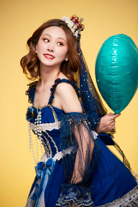 黄色背景下穿着欧式宫廷晚装庆祝生日的少女图片