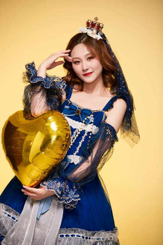 黄色背景下穿着欧式宫廷晚装庆祝生日的少女图片