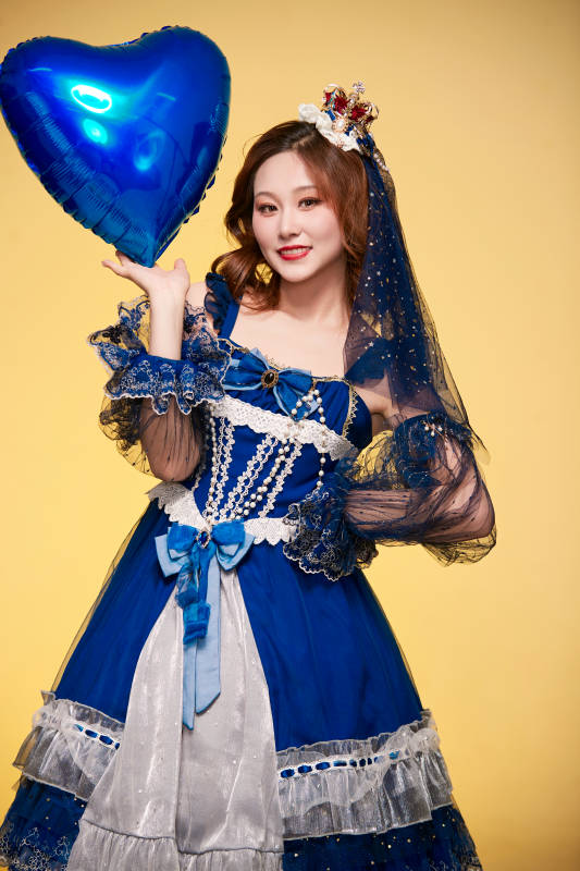 黄色背景下穿着欧式宫廷晚装庆祝生日的少女图片