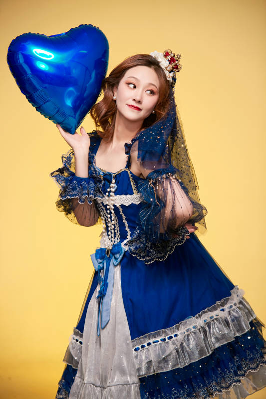 黄色背景下穿着欧式宫廷晚装庆祝生日的少女图片