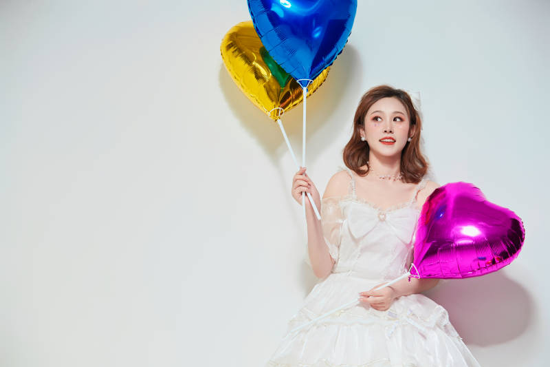 穿着公主裙手拿气球庆祝生日的亚洲女性图片