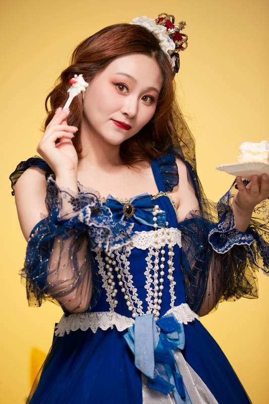 黄色背景下穿着欧式宫廷晚装庆祝生日的少女图片