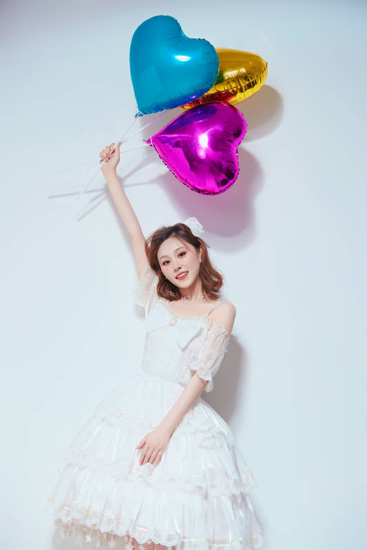穿着公主裙手拿气球庆祝生日的亚洲女性图片