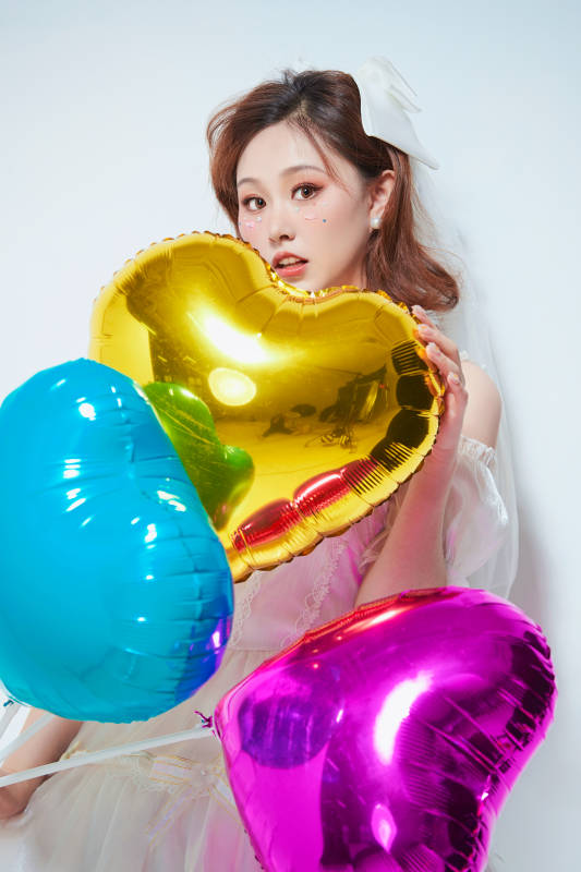 穿着公主裙手拿气球庆祝生日的亚洲女性图片