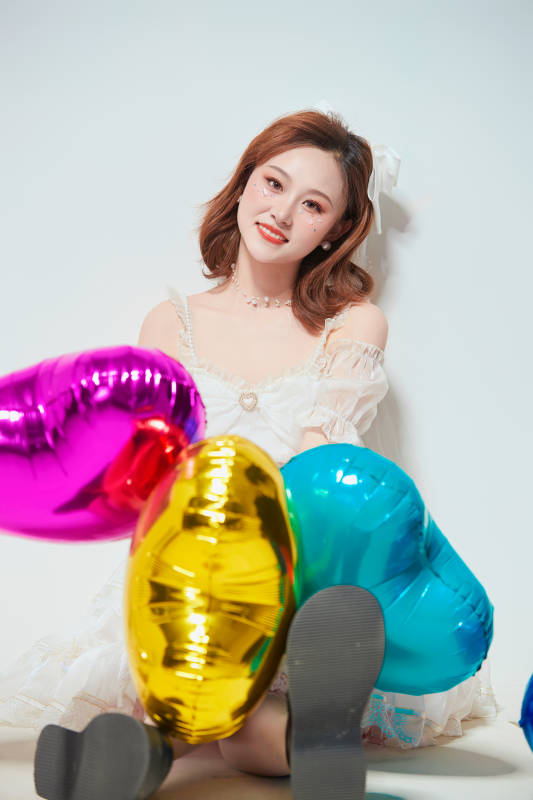 穿着公主裙手拿气球庆祝生日的亚洲女性图片