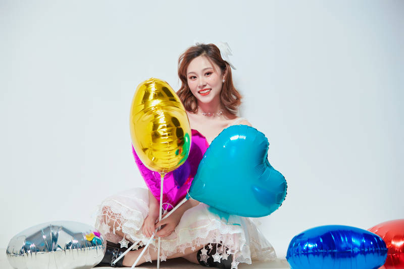 穿着公主裙手拿气球庆祝生日的亚洲女性图片