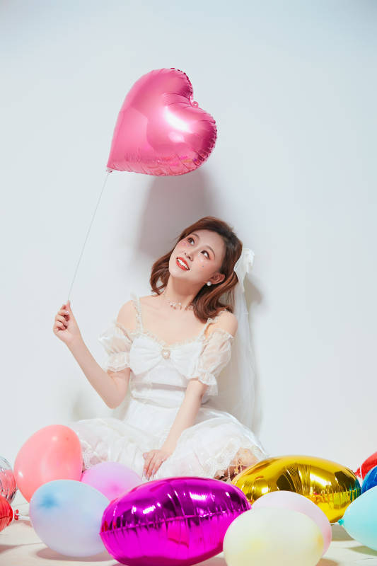 穿着公主裙手拿气球庆祝生日的亚洲女性图片
