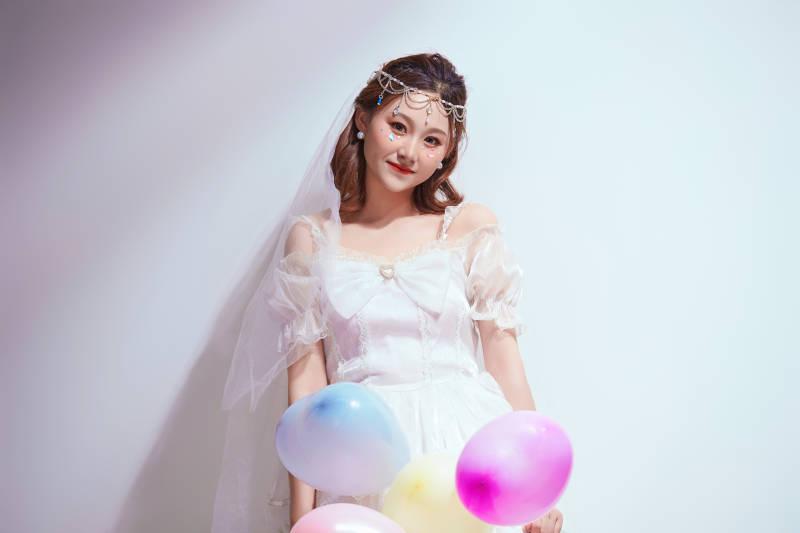 穿着公主裙手拿气球庆祝生日的亚洲女性图片