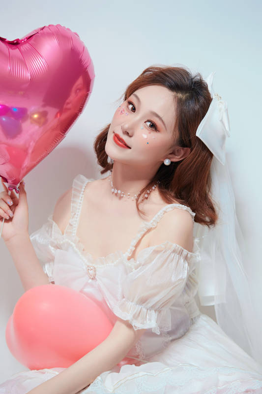 穿着公主裙手拿气球庆祝生日的亚洲女性图片