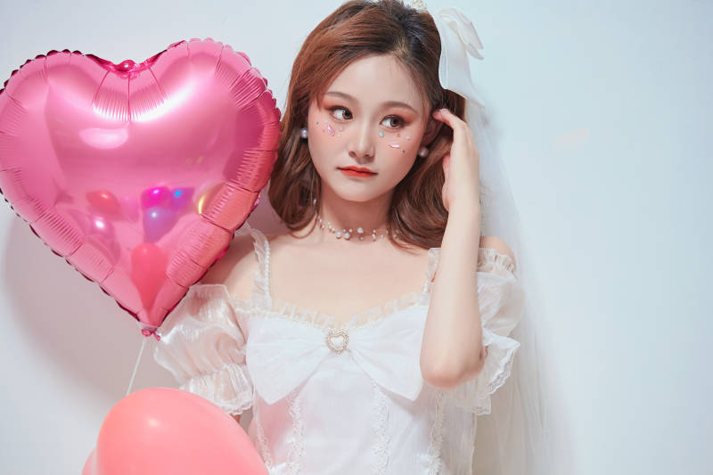 穿着公主裙手拿气球庆祝生日的亚洲女性图片