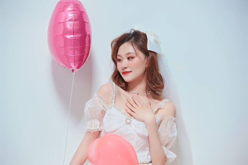 穿着公主裙手拿气球庆祝生日的亚洲女性图片