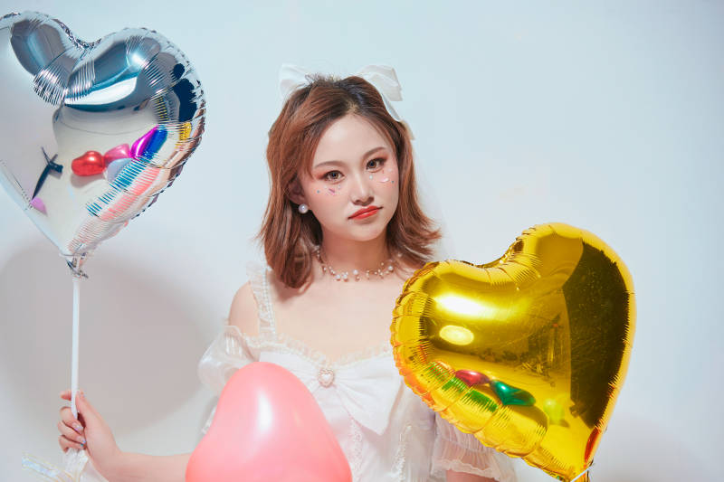 穿着公主裙手拿气球庆祝生日的亚洲女性图片