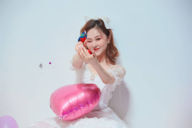 穿着公主裙手拿气球庆祝生日的亚洲女性图片