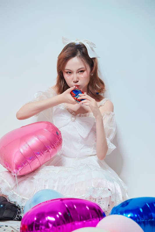 穿着公主裙手拿气球庆祝生日的亚洲女性图片