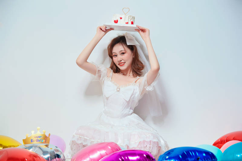 穿着公主裙手捧蛋糕庆祝生日的亚洲女性图片