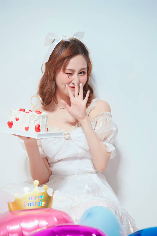 穿着公主裙手捧蛋糕庆祝生日的亚洲女性图片