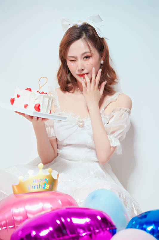 穿着公主裙手捧蛋糕庆祝生日的亚洲女性图片