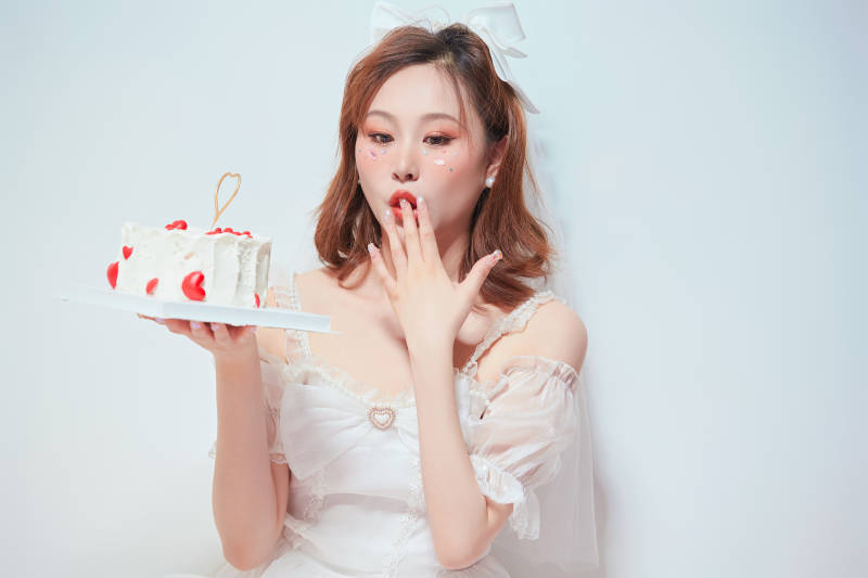 穿着公主裙手捧蛋糕庆祝生日的亚洲女性图片