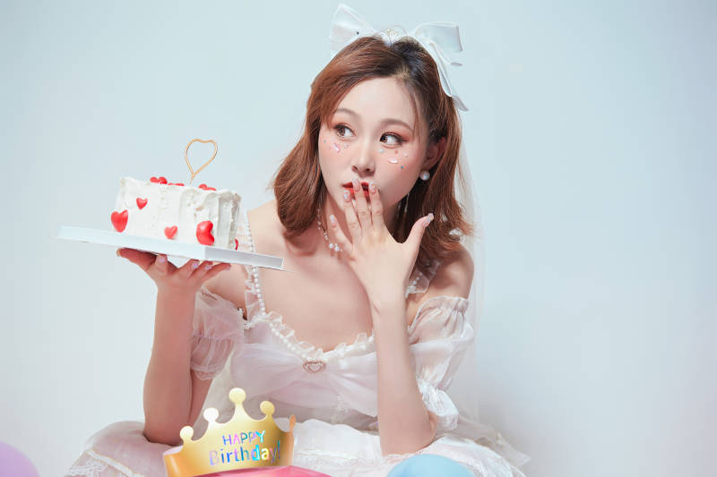 穿着公主裙手捧蛋糕庆祝生日的亚洲女性图片