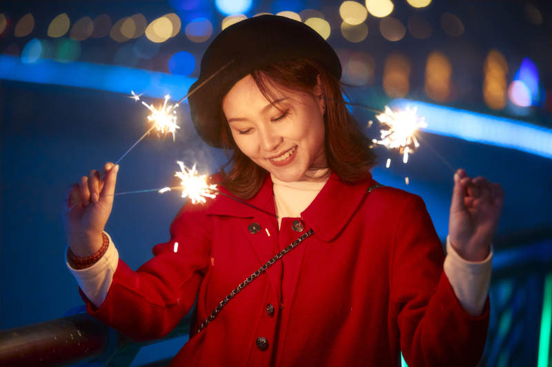 夜晚燃放仙女棒的可爱亚洲少女图片