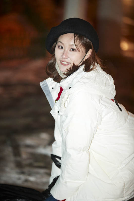 夜晚在繁华灯火的街头拍照的亚洲少女图片