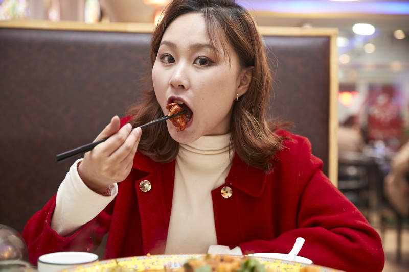 在餐厅吃美味新疆大盘鸡的亚洲少女图片