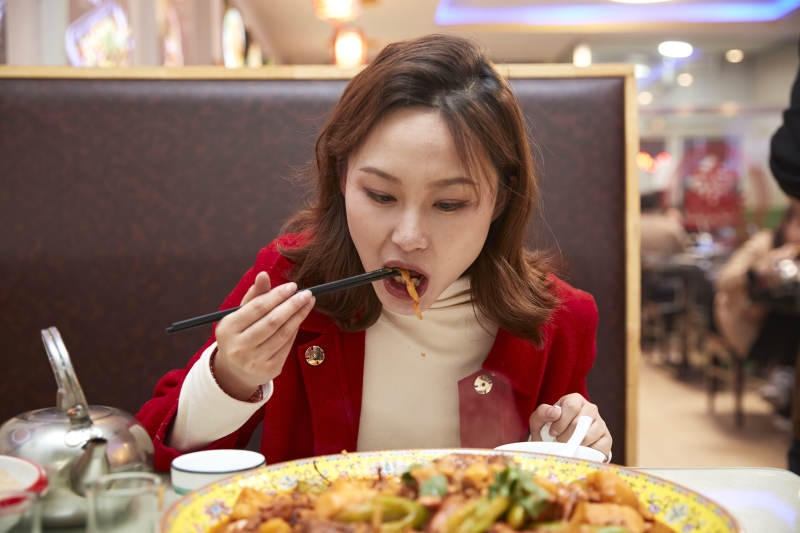 在餐厅吃美味新疆大盘鸡的亚洲少女图片