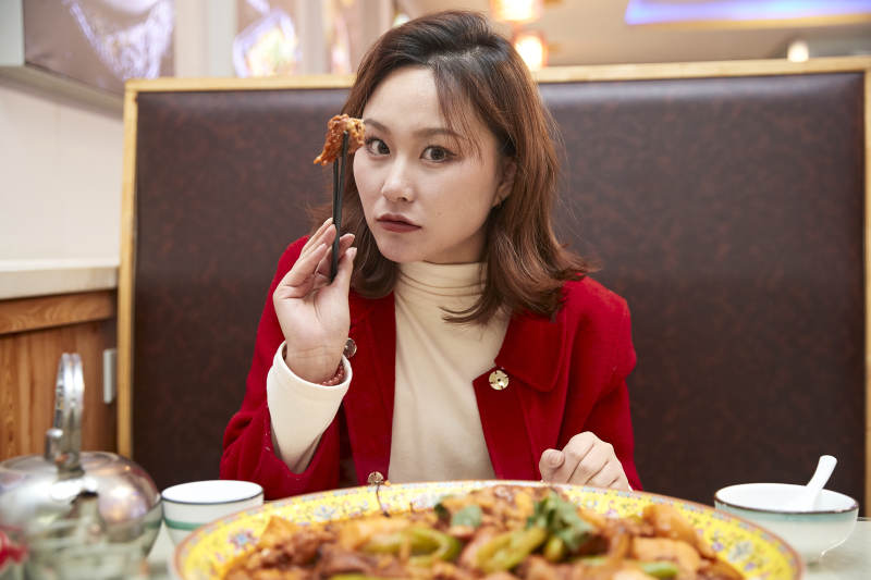 在餐厅吃美味新疆大盘鸡的亚洲少女图片