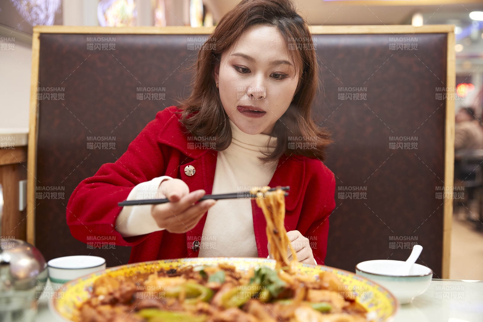 在餐厅吃美味新疆大盘鸡的亚洲少女图片