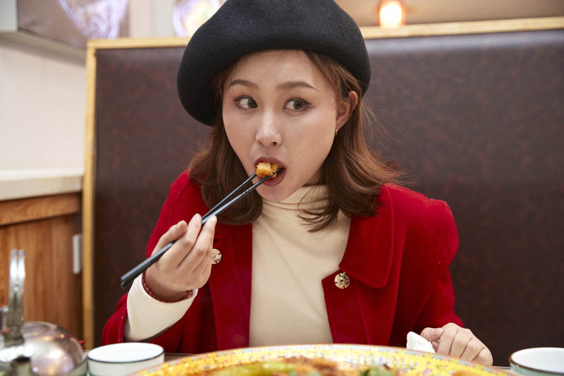 在餐厅吃美味新疆大盘鸡的亚洲少女图片