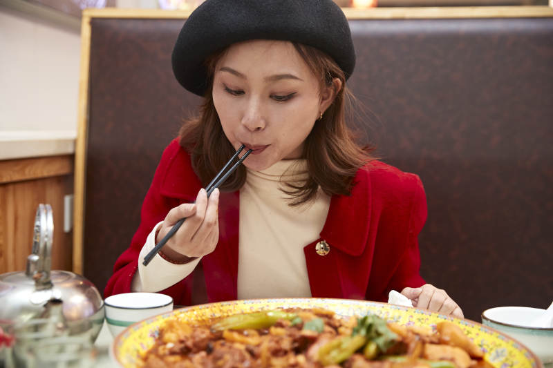 在餐厅吃美味新疆大盘鸡的亚洲少女图片