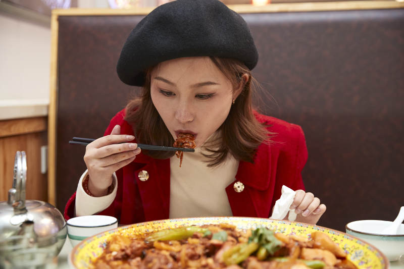 在餐厅吃美味新疆大盘鸡的亚洲少女图片