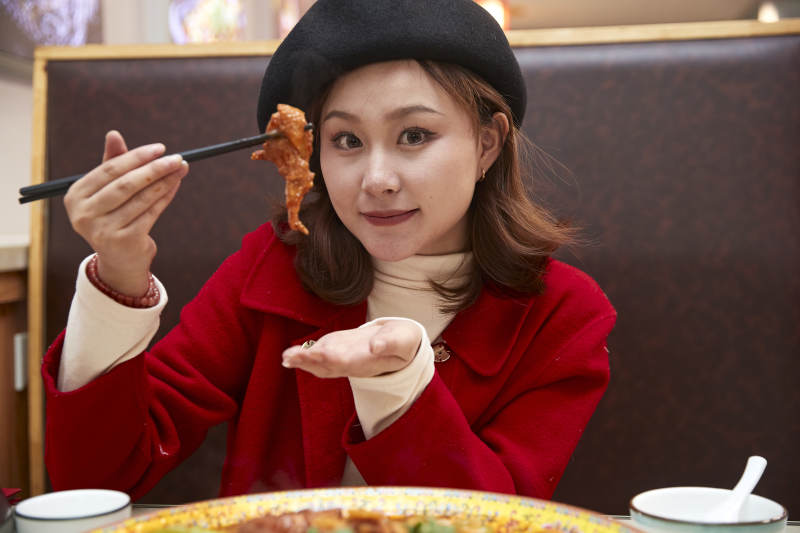 在餐厅吃美味新疆大盘鸡的亚洲少女图片