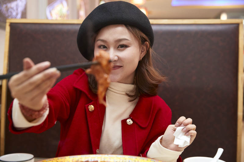 在餐厅吃美味新疆大盘鸡的亚洲少女图片